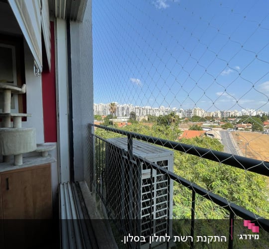 רשת יונים מותקנת על מרפסת עם נוף עירוני